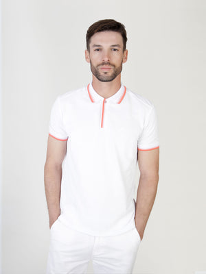 A man wearing a white polo with red collar and cuff detail, designed for the summer adventures. Menswear UK.