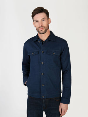 A man wearing a lightweight stretch denim jacket, that was designed in the UK for men.