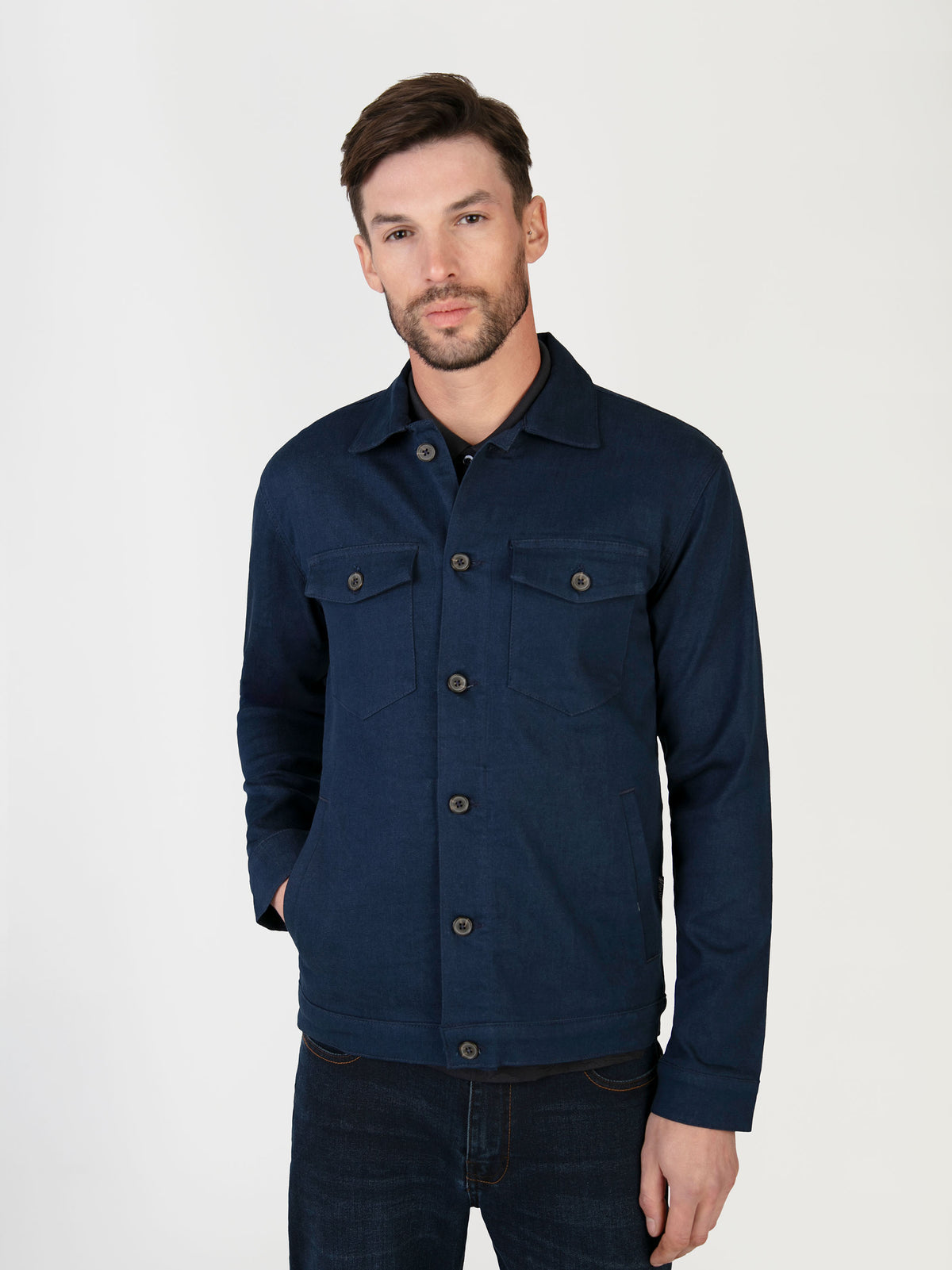 A man wearing a lightweight stretch denim jacket, that was designed in the UK for men.