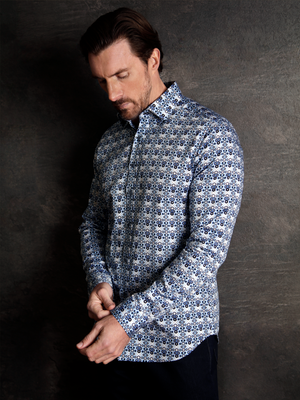 Man wearing a luxurious long sleeve platinum navy and blue shirt with a geo-metric pattern on a textured background.